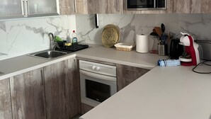 Una cucina moderna con mobili in legno, forno a microonde integrato, lavello e piano cottura.