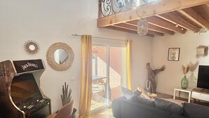 A living room with a piano, a sofa, a patterned rug, and a balcony with a wrought iron railing. - Spacious 5-bedroom villa with AC in perfect Claret (Claret)