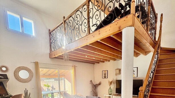 A room with a foosball table, a sofa, a dining table, and a staircase with a decorative railing. - Spacious 5-bedroom villa with AC in perfect Claret (Claret)
