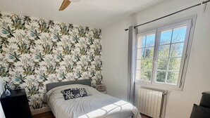 A bedroom with a bed, a ceiling fan, a radiator, and a window. - Spacious 5-bedroom villa with AC in perfect Claret (Claret)