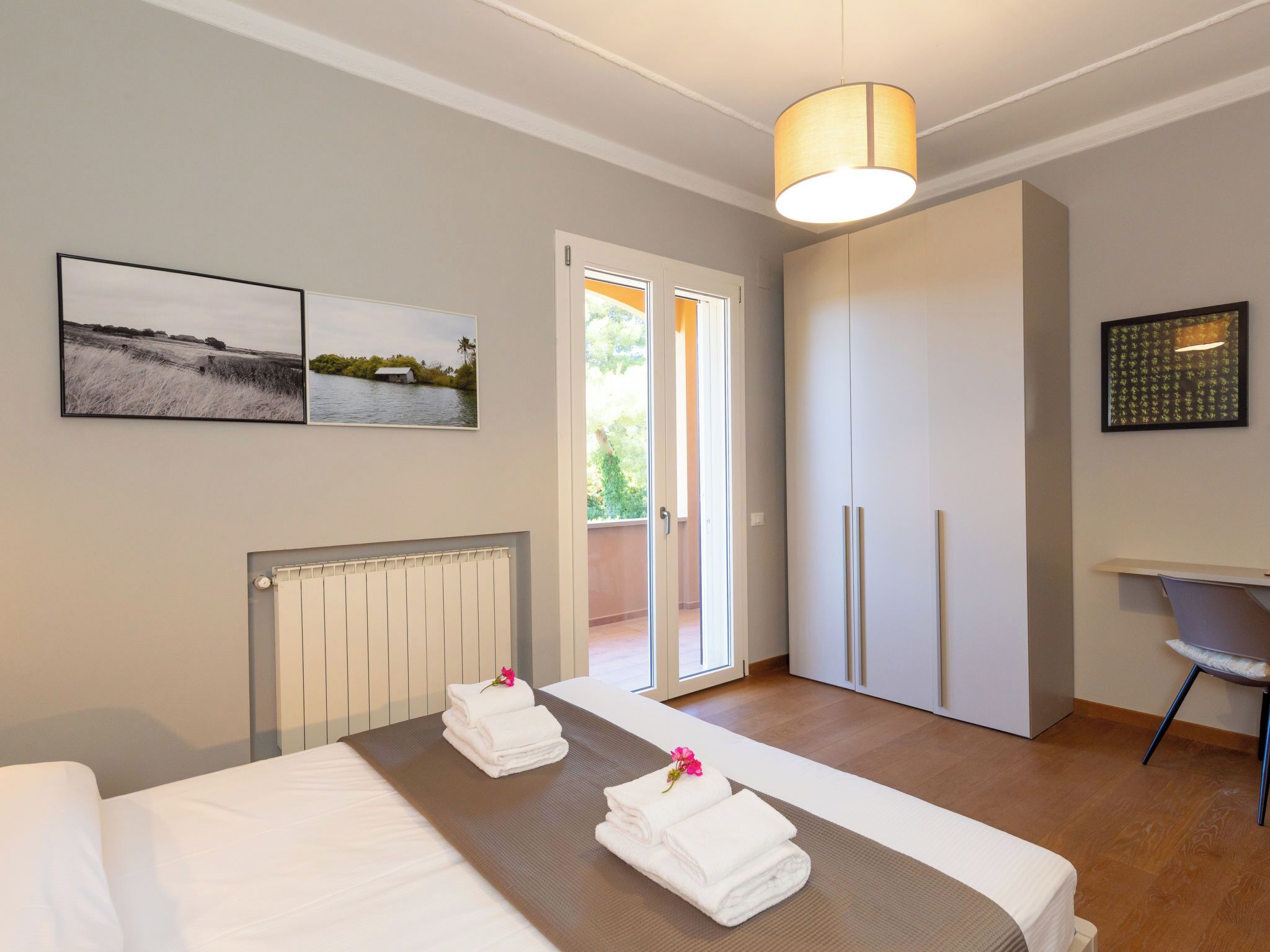 Una camera da letto con un letto, un termosifone, una scrivania, una sedia e un armadio.