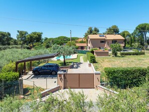 A residential property with a covered carport, a swimming pool, and a large house with a tiled roof. - Rose Adriano Home by Interhome (Cecina)