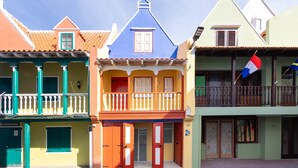 Uma fileira de edifícios coloridos com varandas, portas e janelas.