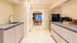 Uma cozinha moderna com uma ilha central, uma pia e um espaço para refeições ao fundo.