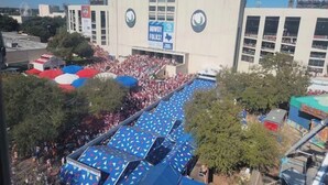 Un grande stadio con la scritta 'COTTON BOWL', circondato da alberi e da una folla.