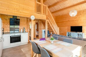 Ein Holzblockhaus mit Küche, Essbereich und Wohnzimmer.