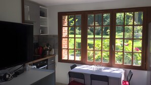 A kitchen with a large window, a dining table, and chairs. - Holiday Home 'Gite Les Rosiers' with Private Garden (Eu)