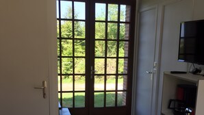 A room with a tiled floor, a bench, a TV, and a cabinet. - Holiday Home 'Gite Les Rosiers' with Private Garden (Eu)