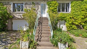 Ein Haus mit Eingangsbereich, einer Treppe und einem Garten.