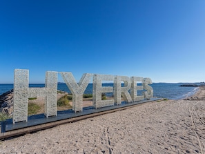 Uma praia com a palavra 'LYERES' escrita em grandes letras em uma passarela.