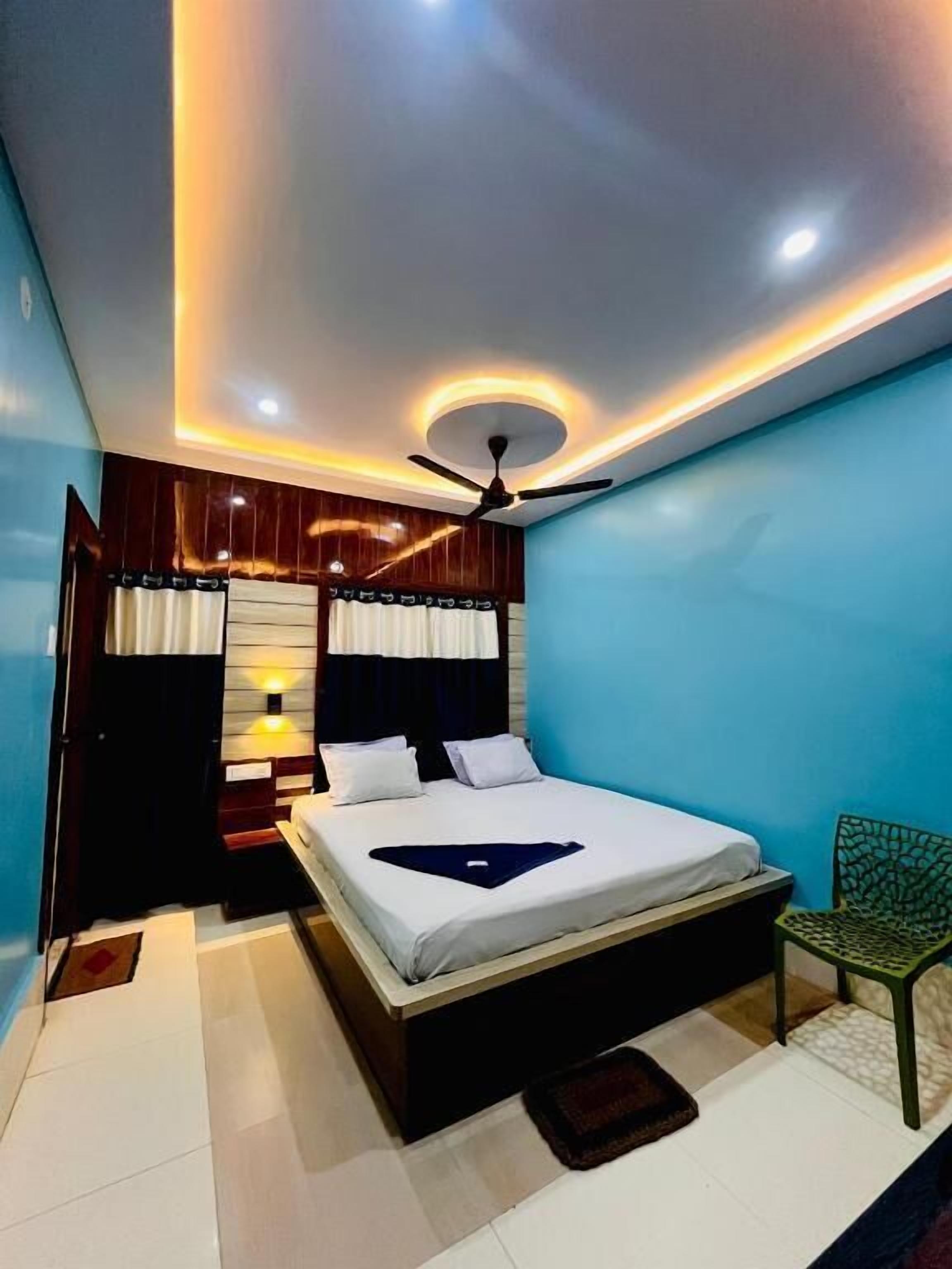 A bedroom with a bed, a ceiling fan, and a nightstand.