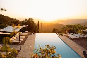 A swimming pool with lounge chairs and a view of the sunset over a hilly landscape. - Villa La Torre Tenuta Lonciano with Private Pool, AC, and Sauna (Sesto Fiorentino)