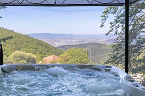 A hot tub with a view of a valley and mountains.