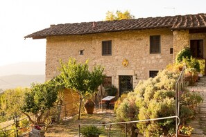 A stone building with a tiled roof, a small door, and a window. There is a tree in front of the building and a large pot on the ground. - Villa La Torre Tenuta Lonciano with Private Pool, AC, and Sauna (Sesto Fiorentino)