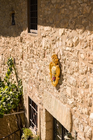 Un edificio de piedra con una ventana y un escudo de armas.