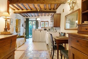 Une chambre traditionnelle comprenant un lit, des meubles en bois, une table à manger et un coin cuisine avec une cuisinière.