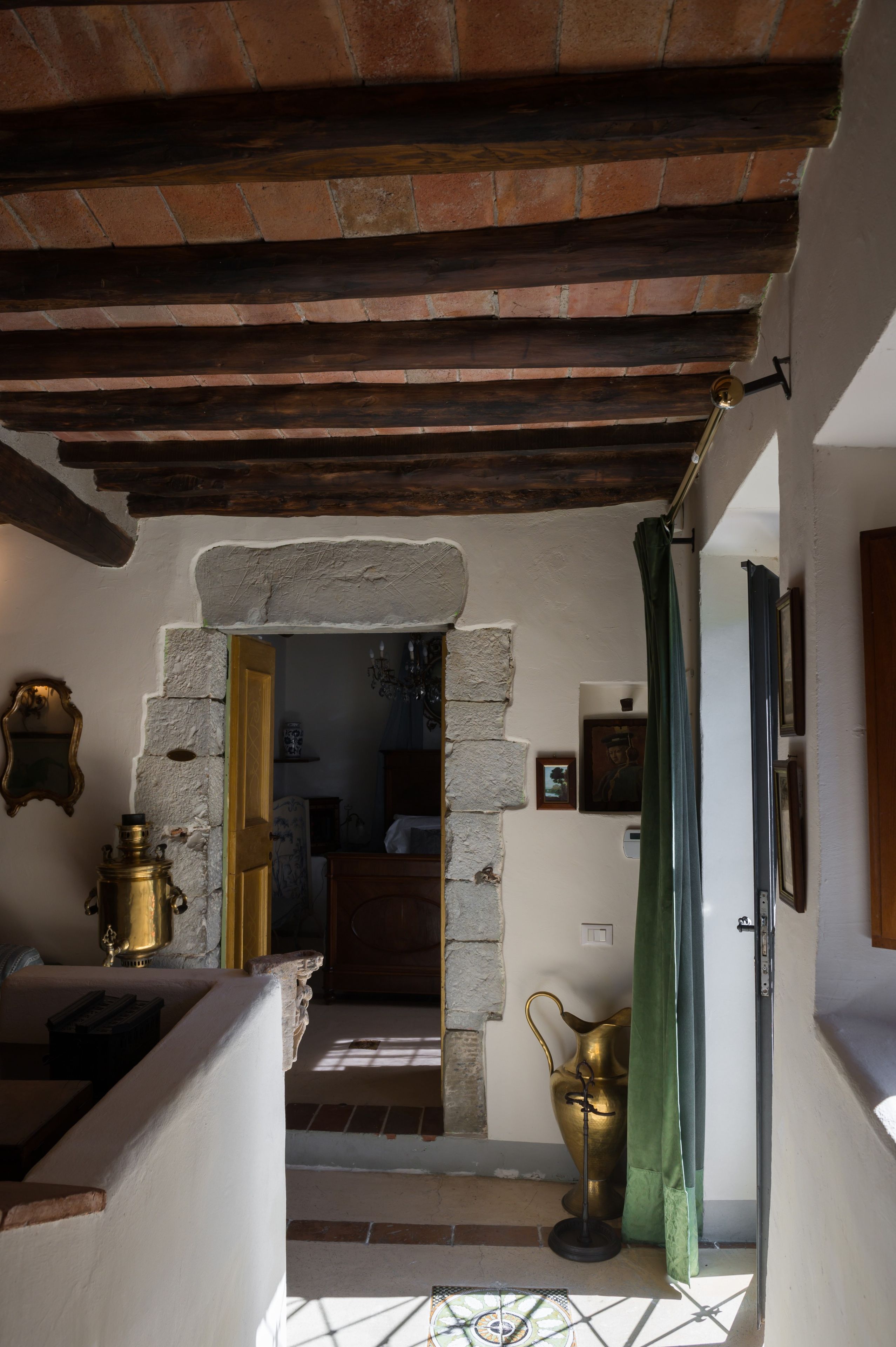A rustic interior with exposed brick walls, a stone archway, and a wooden ceiling.