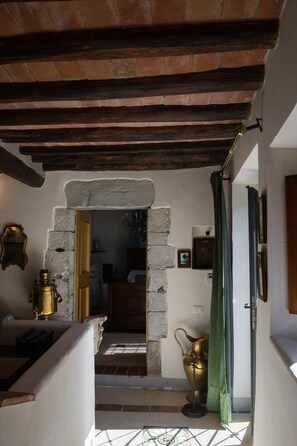 Ein rustikales Interieur mit freiliegenden Backsteinwänden, einem steinernen Bogen und einer Holzzielende.