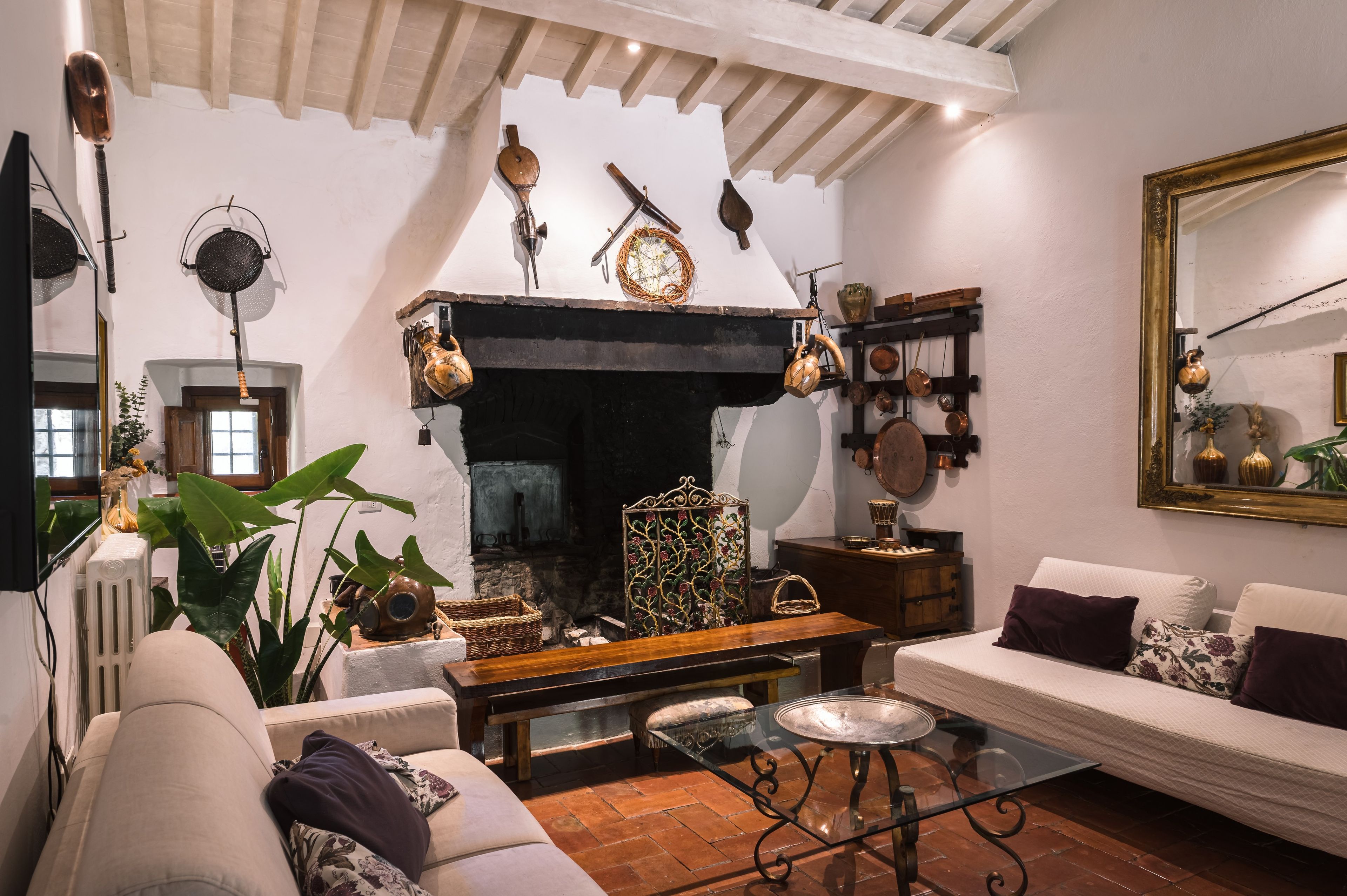 Un salon chaleureux avec une cheminée, un canapé, une table basse et divers objets de décoration.