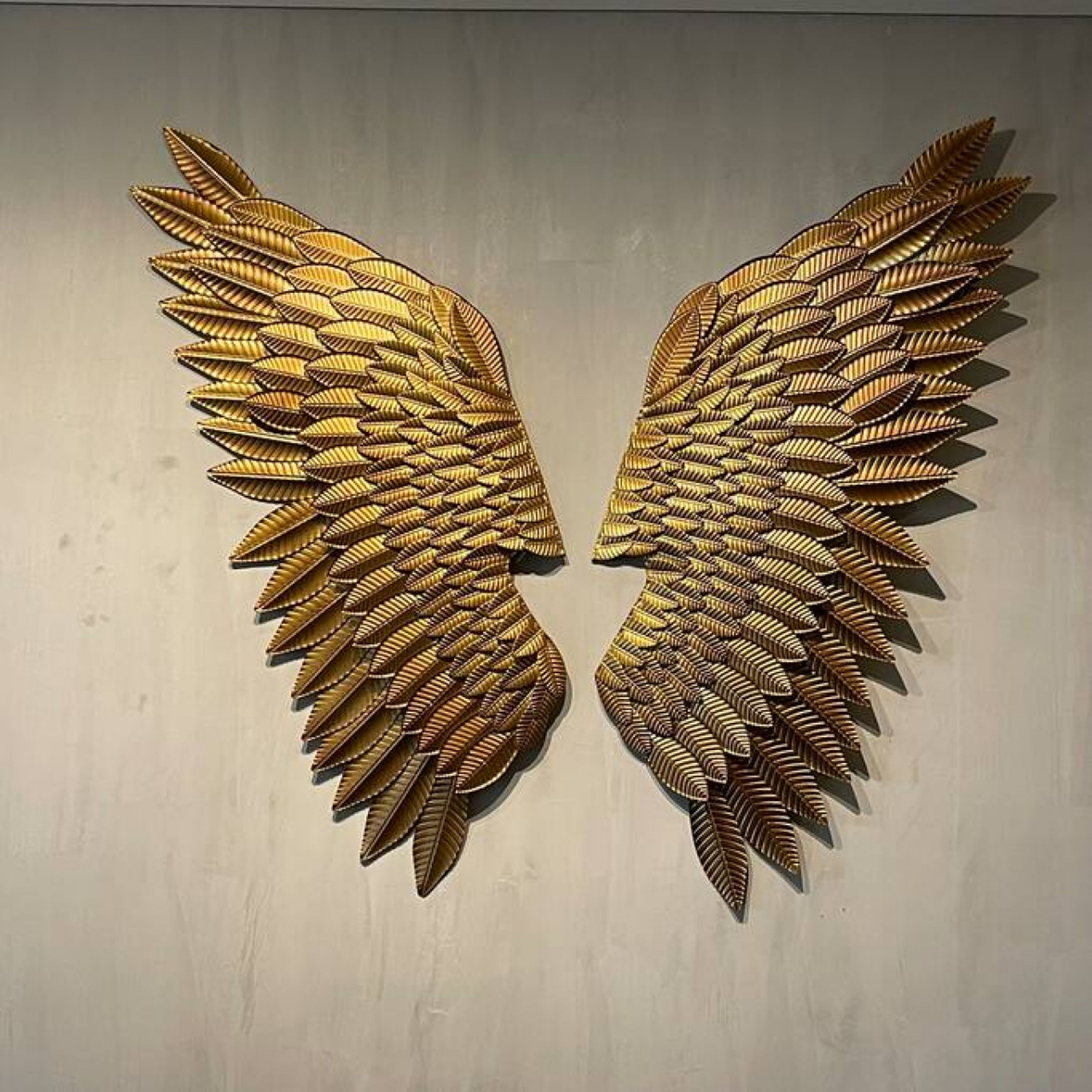 Un par de adornos dorados con forma de plumas.