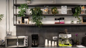 A kitchen with a coffee machine, a toaster, and shelves with coffee bags and plants. - Cyan 703 - 2BR in Medell n (Medellín)