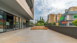Un bâtiment moderne doté de grandes fenêtres, d’un toit plat et d’une cour dallée.