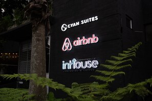 A building with signage for 'Cyan Suites,' 'Airbnb,' and 'Inhouse coworking & coffee.' - Cyan 1001 - 2BR in Medell n (Medellín)