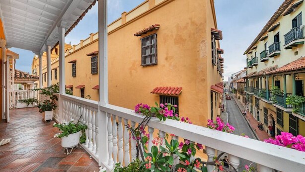 A covered outdoor area with a balcony, potted plants, and a street view. - Amazing Colonial Mansion-8br-private Pool-old City (Cartagena)