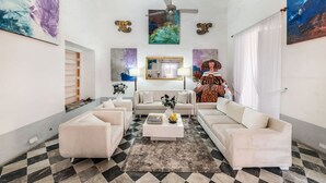 A spacious living room with a high ceiling, a central coffee table, and a sofa set. - Amazing Colonial Mansion-8br-private Pool-old City (Cartagena)