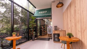 A modern interior with a wooden wall, a green awning, and a view of the outdoors. - Go Living Suites - 1407 (Medellín)