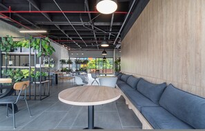 Ein modernes Interieur mit einem runden Tisch, einer Sitzecke und Zimmerpflanzen.