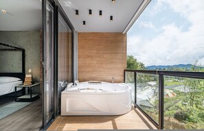 A modern bathroom with a large bathtub, a glass shower enclosure, and a wooden wall. - Olive Country Living - 311 (Envigado)