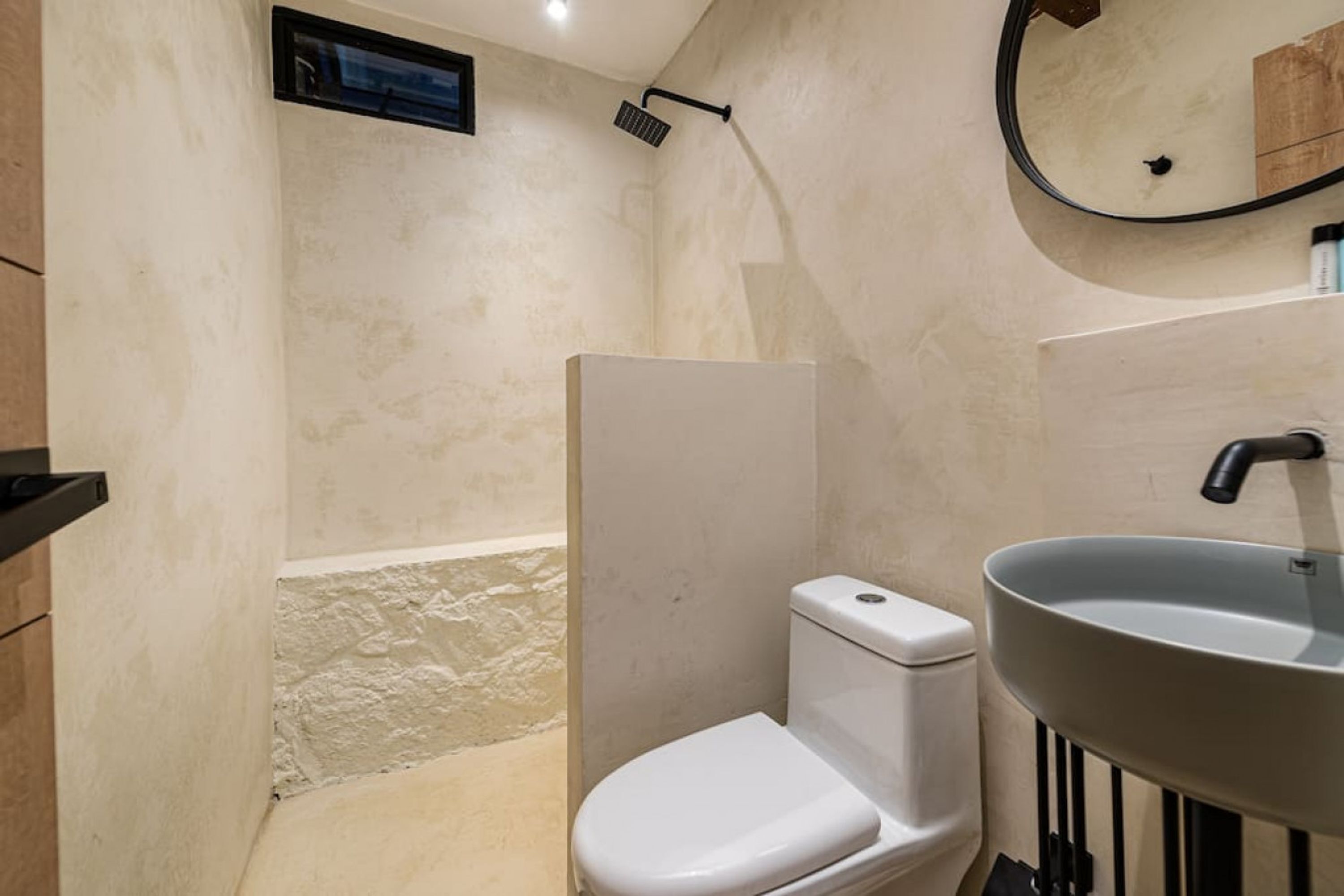 Une salle de bain avec des toilettes, un lavabo et une douche.