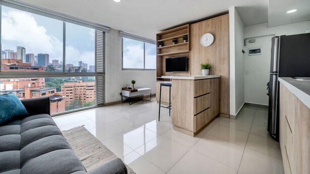 A modern apartment with a kitchen, dining area, and a large window overlooking a cityscape. - Oslo 1801 in Medell n (Medellín)