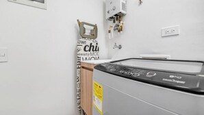 A laundry room with a washing machine, a wall-mounted heater, and a sign with motivational text. - Oslo 1801 in Medell n (Medellín)