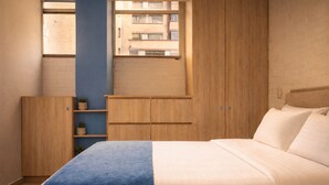 A bedroom with a bed, a window, a wooden wardrobe, and a shelf with plants. - Oslo 609 in Medell n (Medellín)
