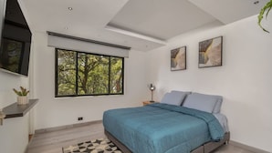 A bedroom with a large window, a bed, a desk, and two paintings on the wall. - 301 - Luxury 3BR Retreat Private Jacuzzi Nightclub AC (Medellín)