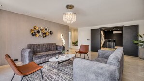 A modern living room with a grey sofa, a coffee table, and a chandelier. - 301 - Luxury 3BR Retreat Private Jacuzzi Nightclub AC (Medellín)