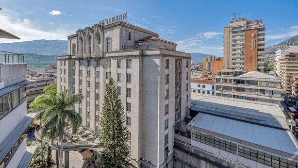 A multi-story building with a central courtyard, surrounded by other buildings. - Nutibara Express - 826 (Medellín)