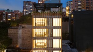 A modern building with multiple floors, large windows, and a rooftop garden. - LIN Hotel Suite Deluxe (Medellín)