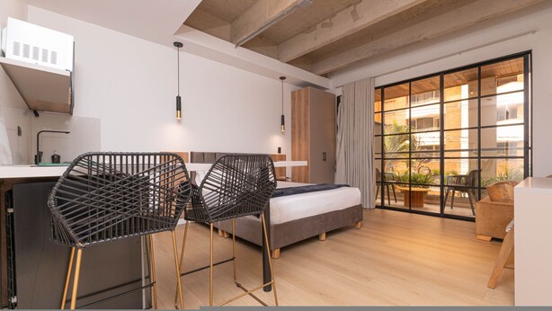 A modern bedroom with a bed, a desk, and two chairs. - Opera 303 in Medell n (Medellín)