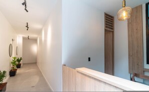 A modern hallway with a light-colored floor, a wooden bench, and a ceiling-mounted light fixture. - Opera 402 in Medell n (Medellín)