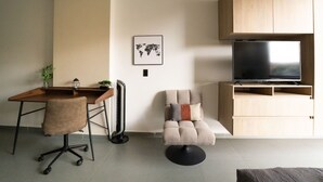 Una sala moderna con un escritorio de madera, una silla de oficina y un sillón cómodo.