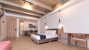 Ein modernes Schlafzimmer mit Bett, Schreibtisch, Stuhl und einer kleinen Küche.