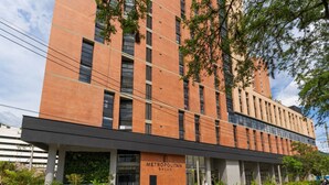 Un edificio moderno con un cartel que dice 'METROPOLITAN SALUD' y un área de acceso cubierta.