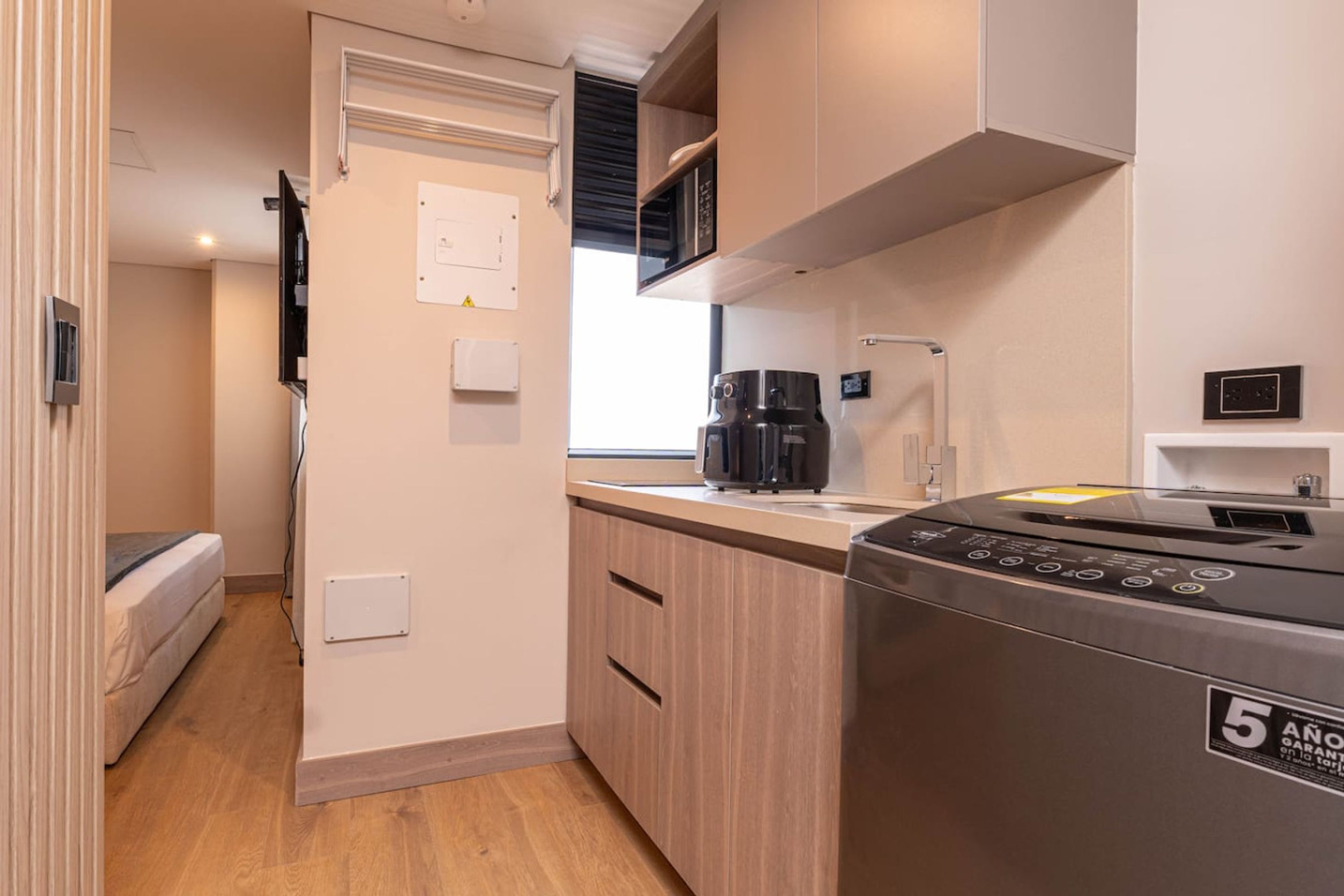 A compact kitchen with a coffee maker, a dishwasher, and a microwave.