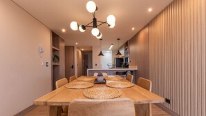 Un comedor con una mesa de madera, individuales tejidos y seis sillas.