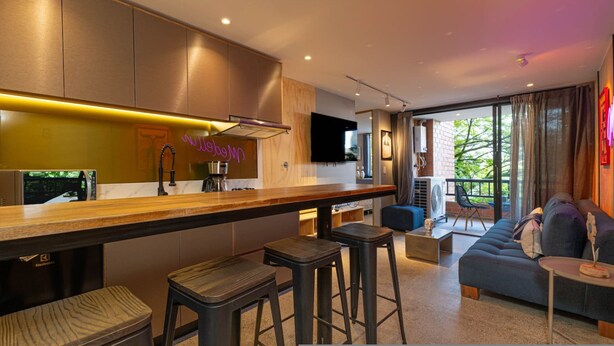 A modern kitchen with a bar area, a sofa, and a TV. - Ayamonte - 105b in Medell n (Medellín)