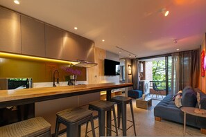 Una cucina moderna con un angolo bar, un divano e una televisione.