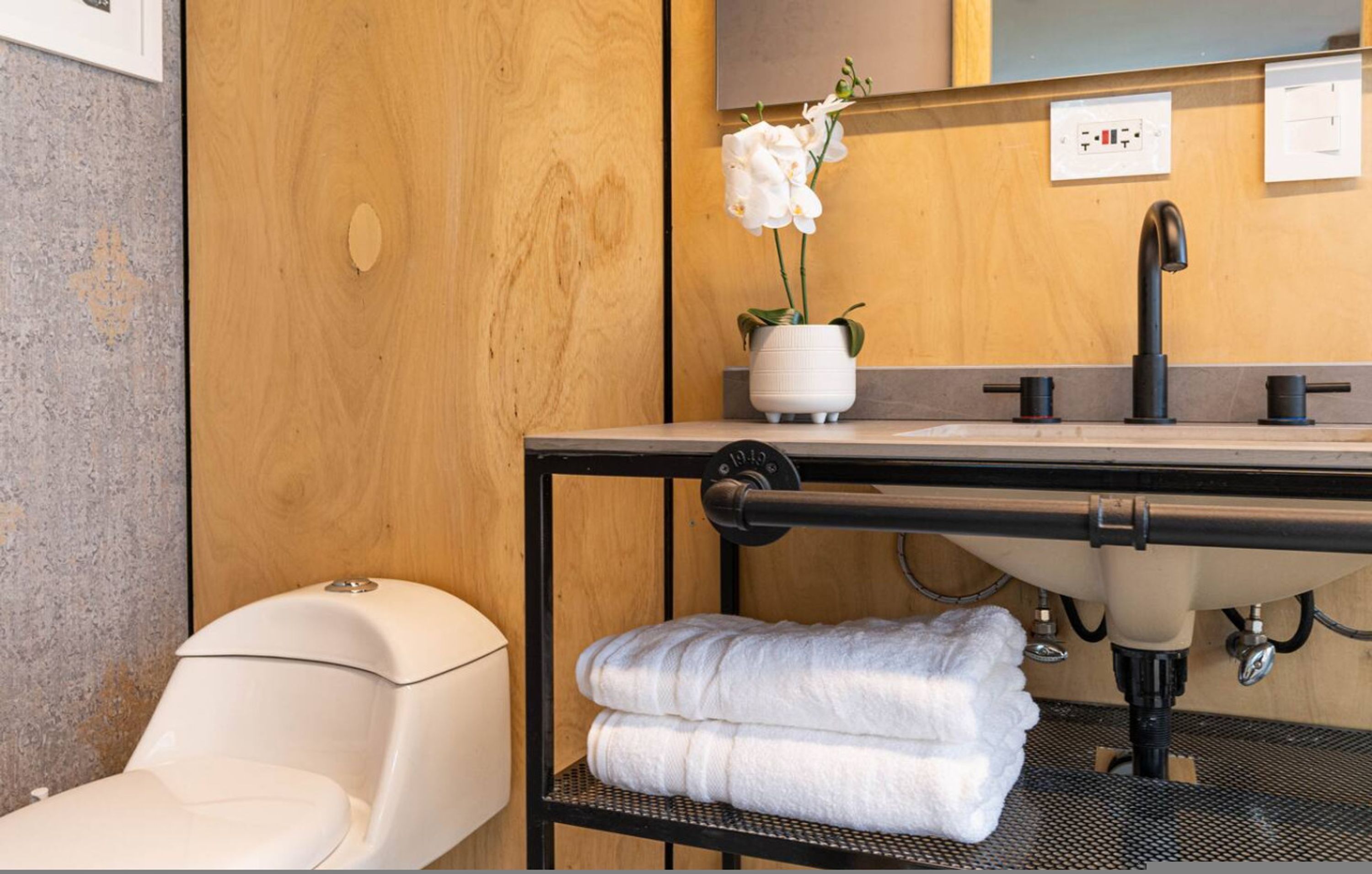 Une salle de bain équipée de toilettes, d’un lavabo et d’un porte-serviettes.